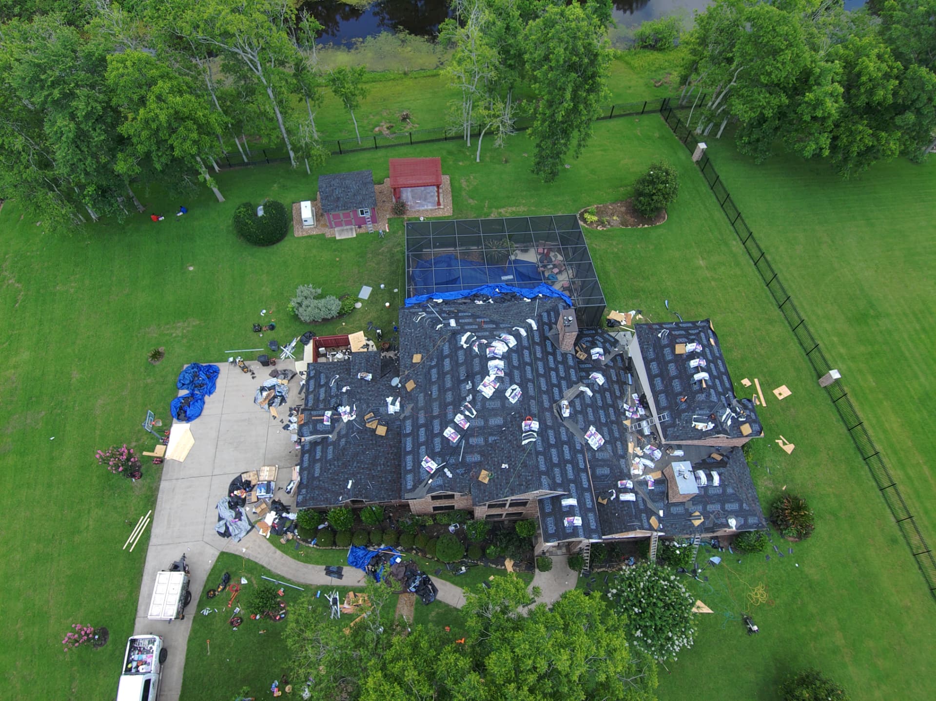 Aerial view of storm-damaged shingles being stripped and replaced