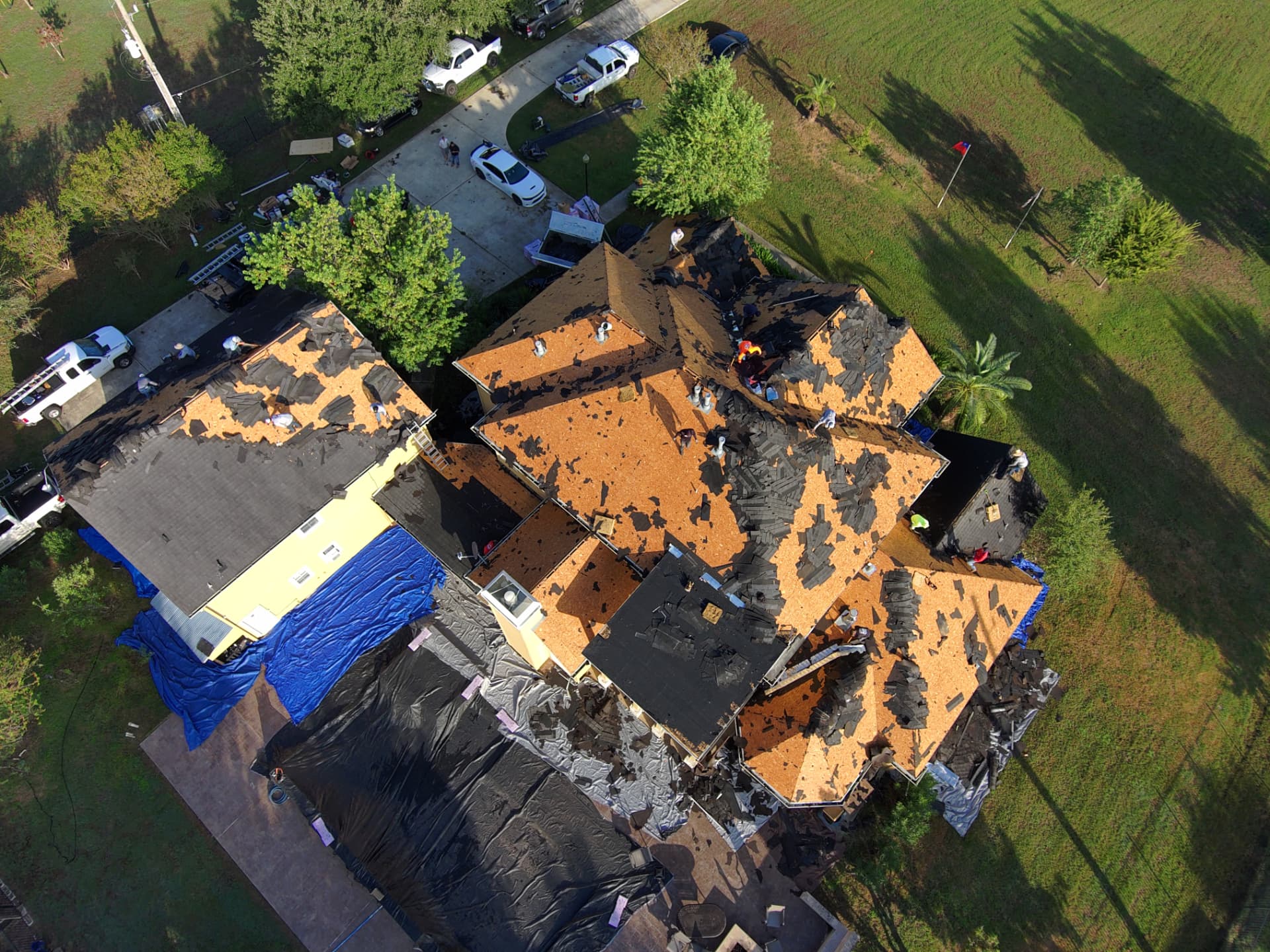 Drone view of new decking and underlayment on a large lakefront home roof replacement