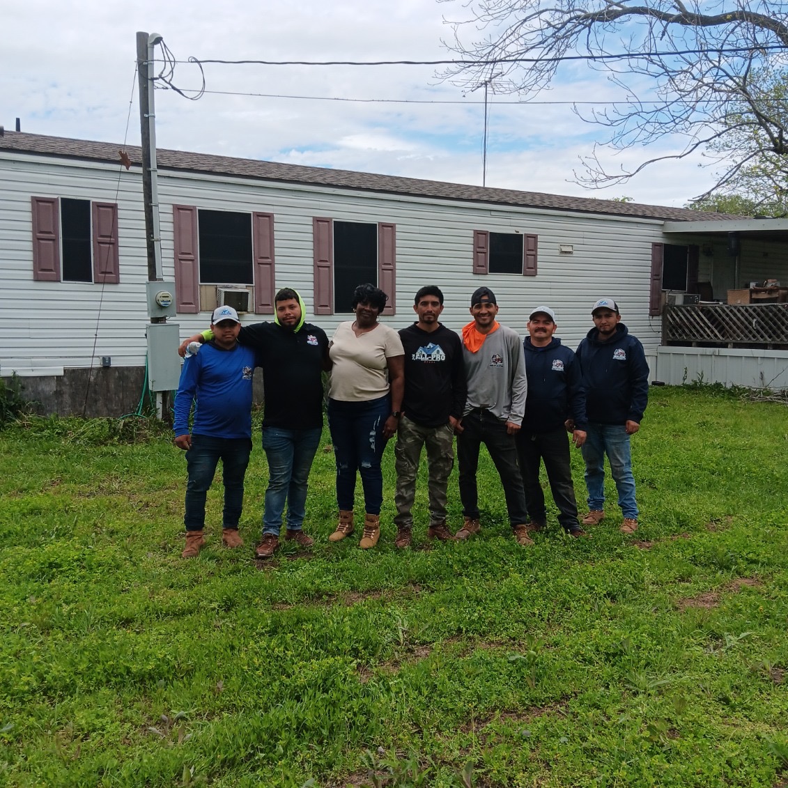 Roofing crew with a homeowner after finishing a roof replacement on a manufactured home in Texas