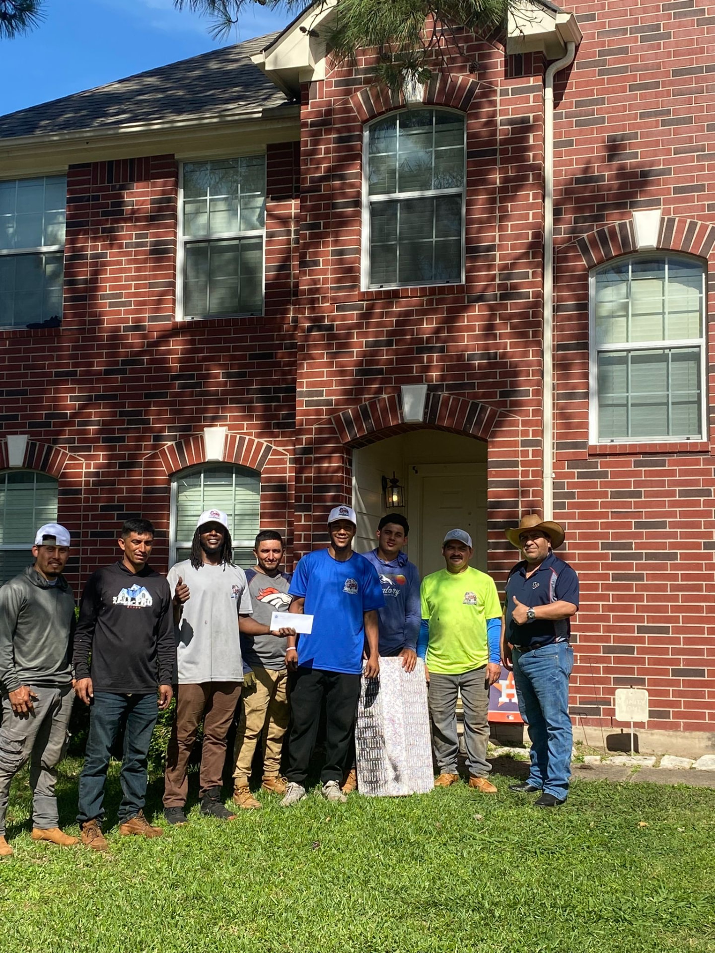 Roofing crew with a happy homeowner after a completed roof replacement in Houston