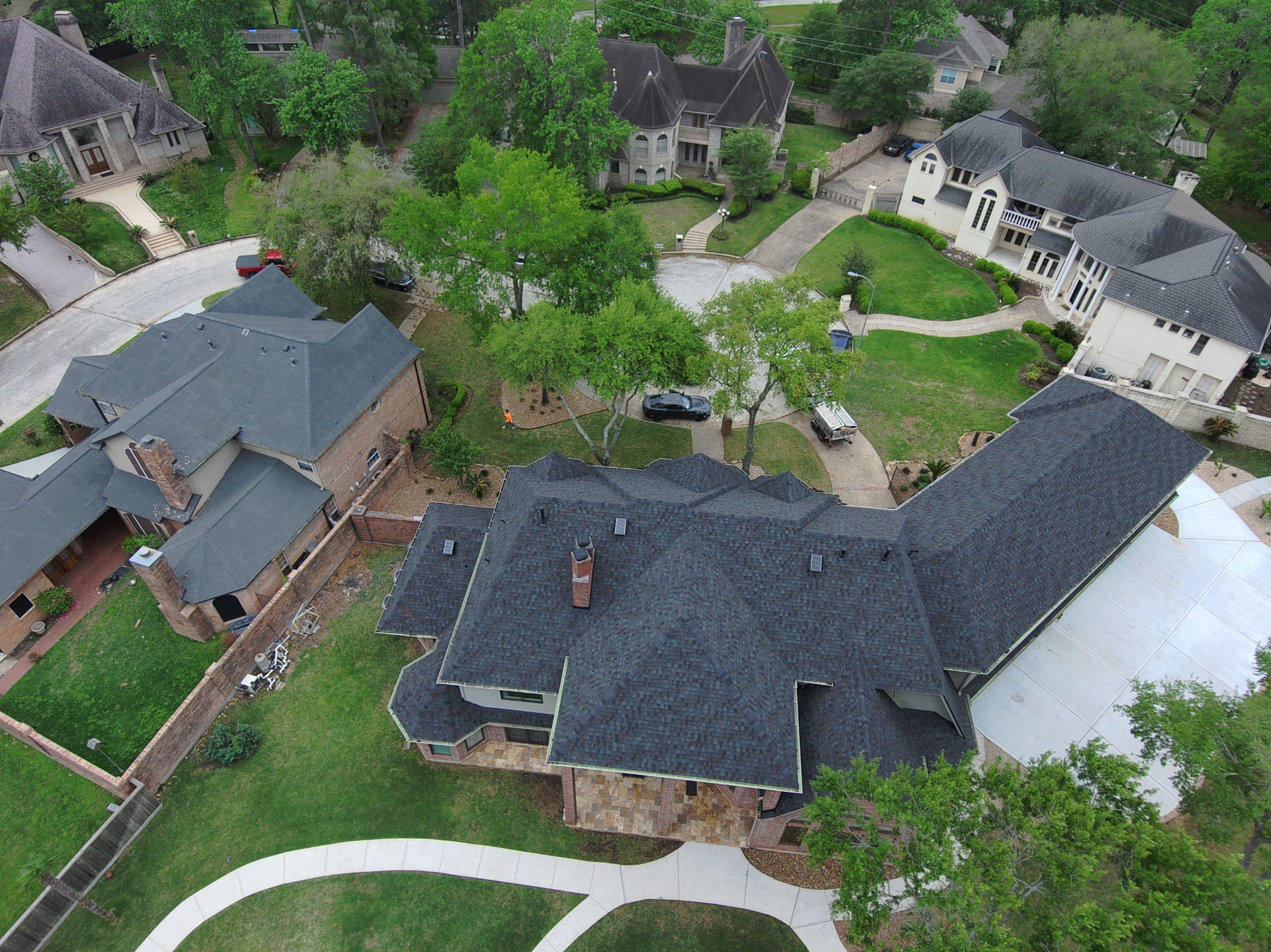 Aerial drone photo of a completed dark architectural shingle roof on a large Houston-area estate home