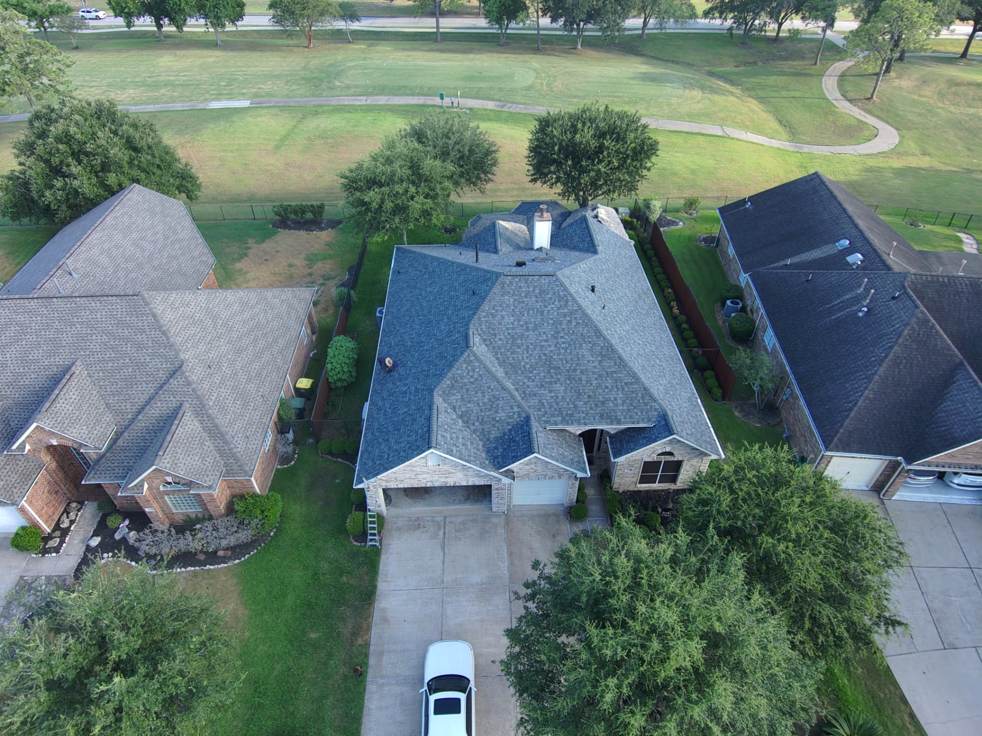 Drone view of a finished shingle roof on a golf-course home in the Houston metro